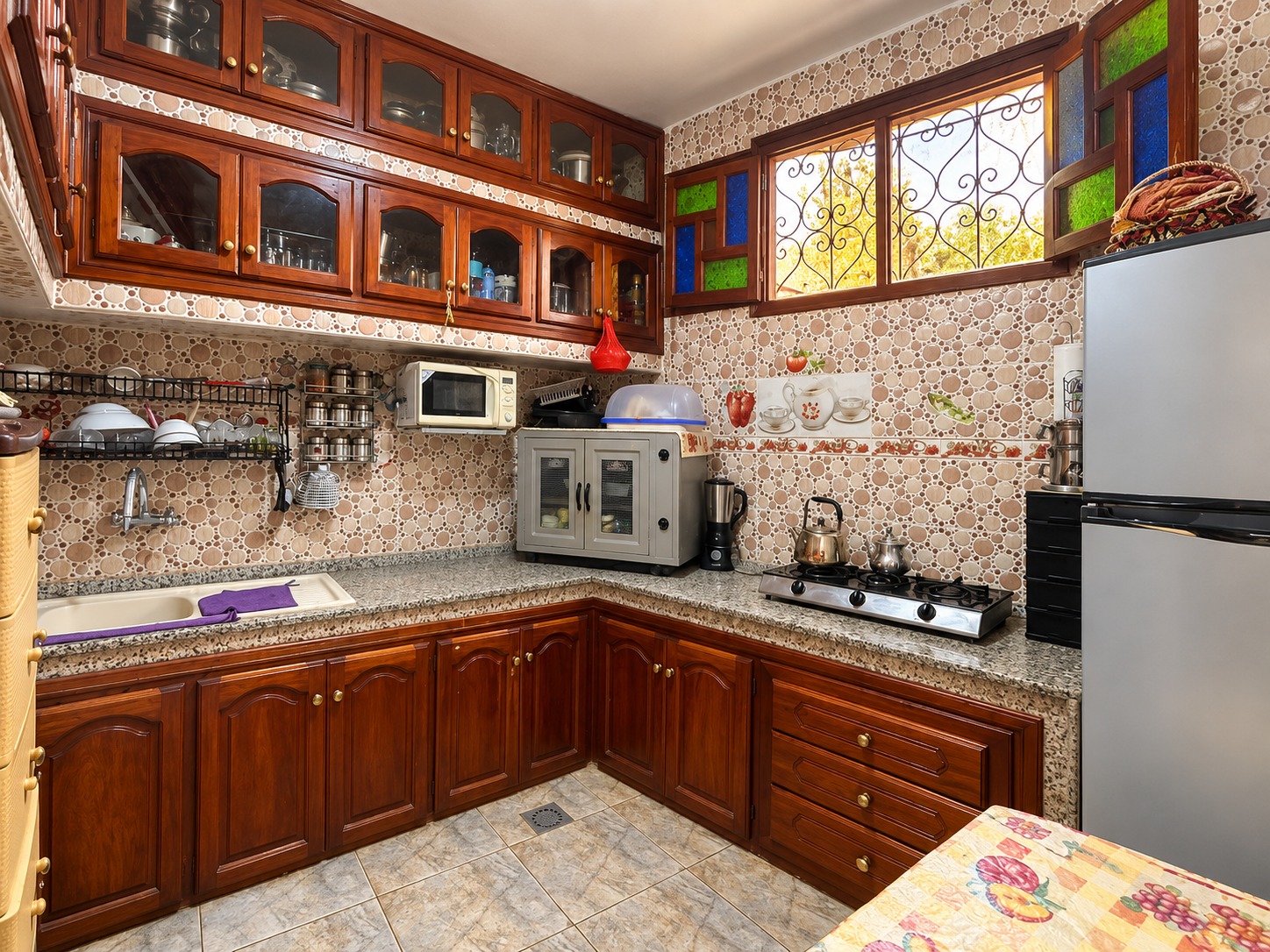 Cuisine traditionnelle chaleureuse illuminée par la fenêtre (1) MAISON TITRÉE 80 m² À VENDRE | SIDI AMARA